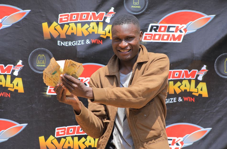 Mwangusha Deo who won 1 million shillings displays his cash.