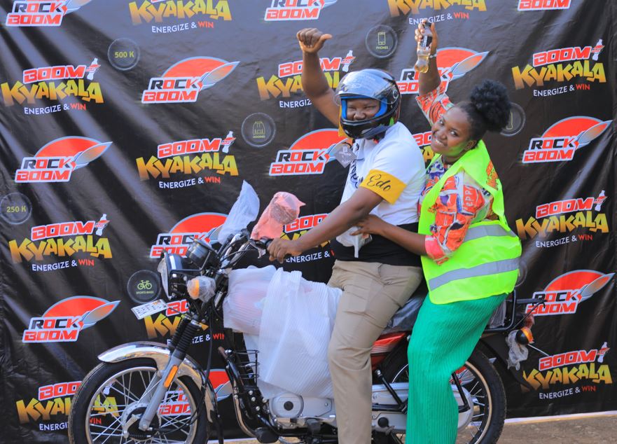 Iradukunda Lixa (sitting behind), one of the lucky winners of a motorbike, celebrates with her father.